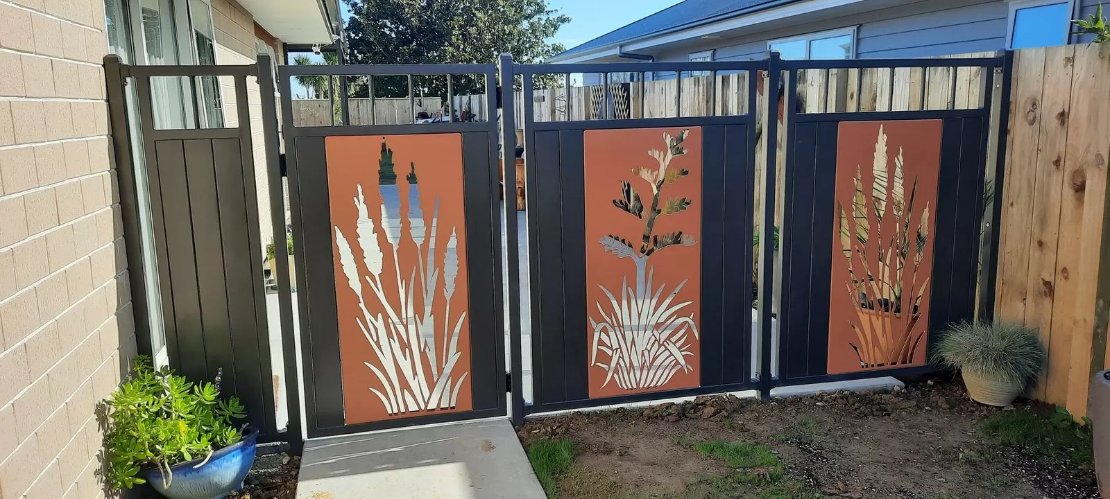Charcoal aluminium side gates and panels with Corten flax inserts