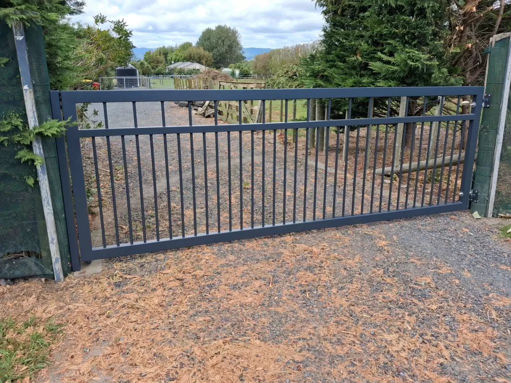 Single aluminium swing gate across a gravel driveway near Hokio Beach, Levin