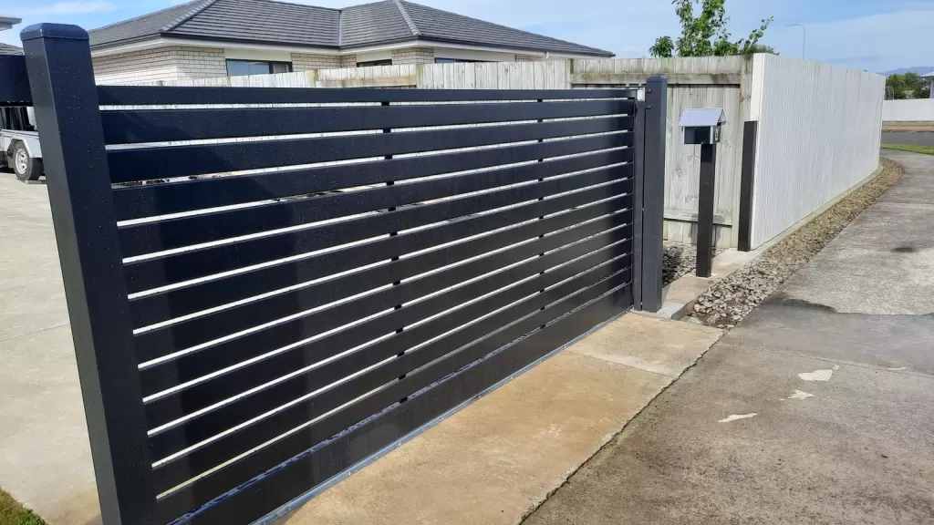 Black aluminium horizontal slat sliding gate across a driveway