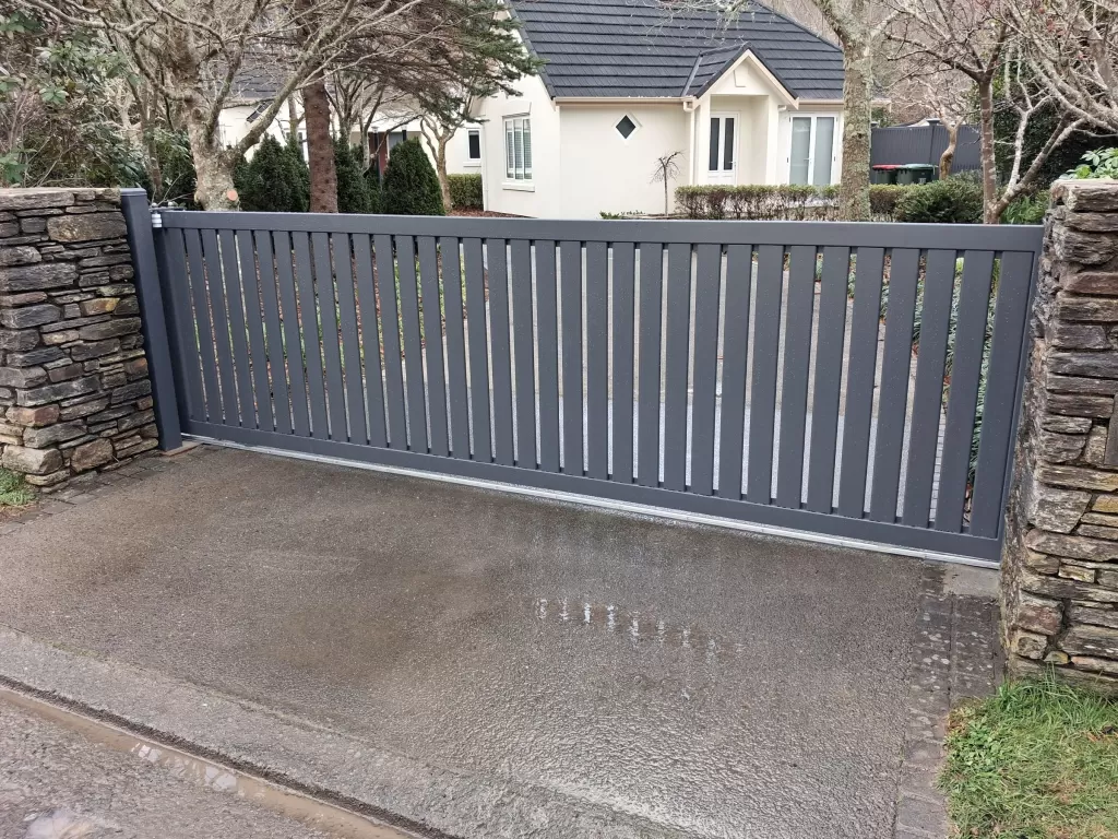 Charcoal aluminium sliding slat gate between stone pillars in Brown Owl, Upper Hutt