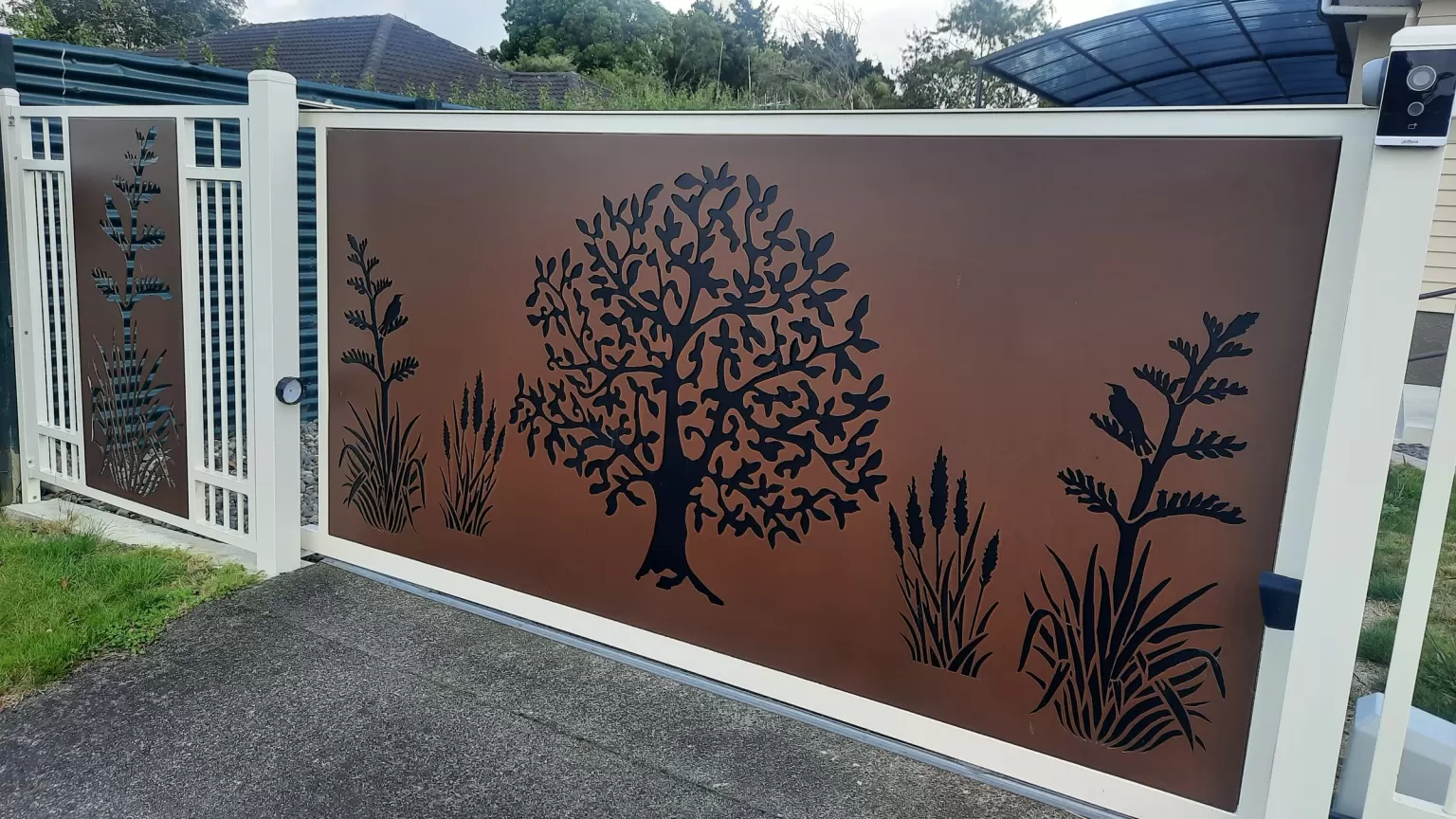Aluminium sliding driveway gate with a laser-cut Corten tree of life panel