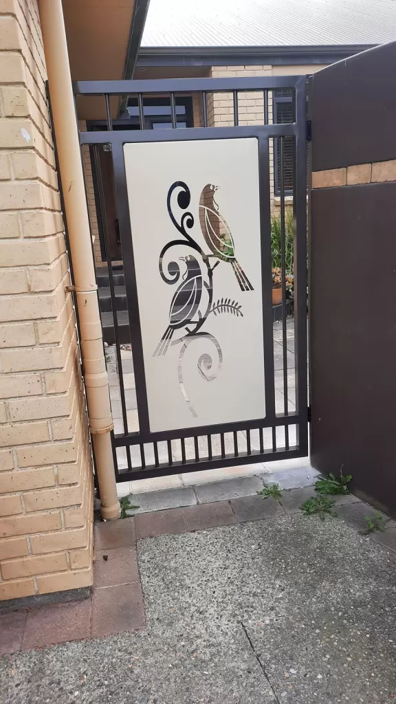Aluminium pedestrian gate with a laser-cut twin tūī panel at Waitārere Beach