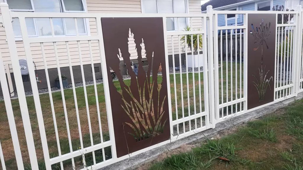White aluminium pool-style fence with Corten decorative panels built in